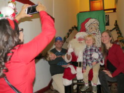 Santa Claus poses for photos with families on the lobby steps of the Admiral Theater.