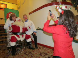 Chef "Wild" Bill Ranniger (left) and Duke Moscrip clown while posing with Santa on the Admiral's lobby steps.