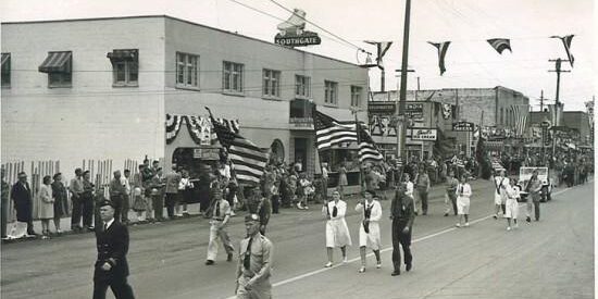 Parade in White Center, Vern Gould leading the procession down 16th Ave SW. Some of the businesses visible are the Southgate Roller Rink, Sherrill's Ice Cream, J&W Tavern, and the A&B Tavern. August 1947 SWSHS 2005.001.0665